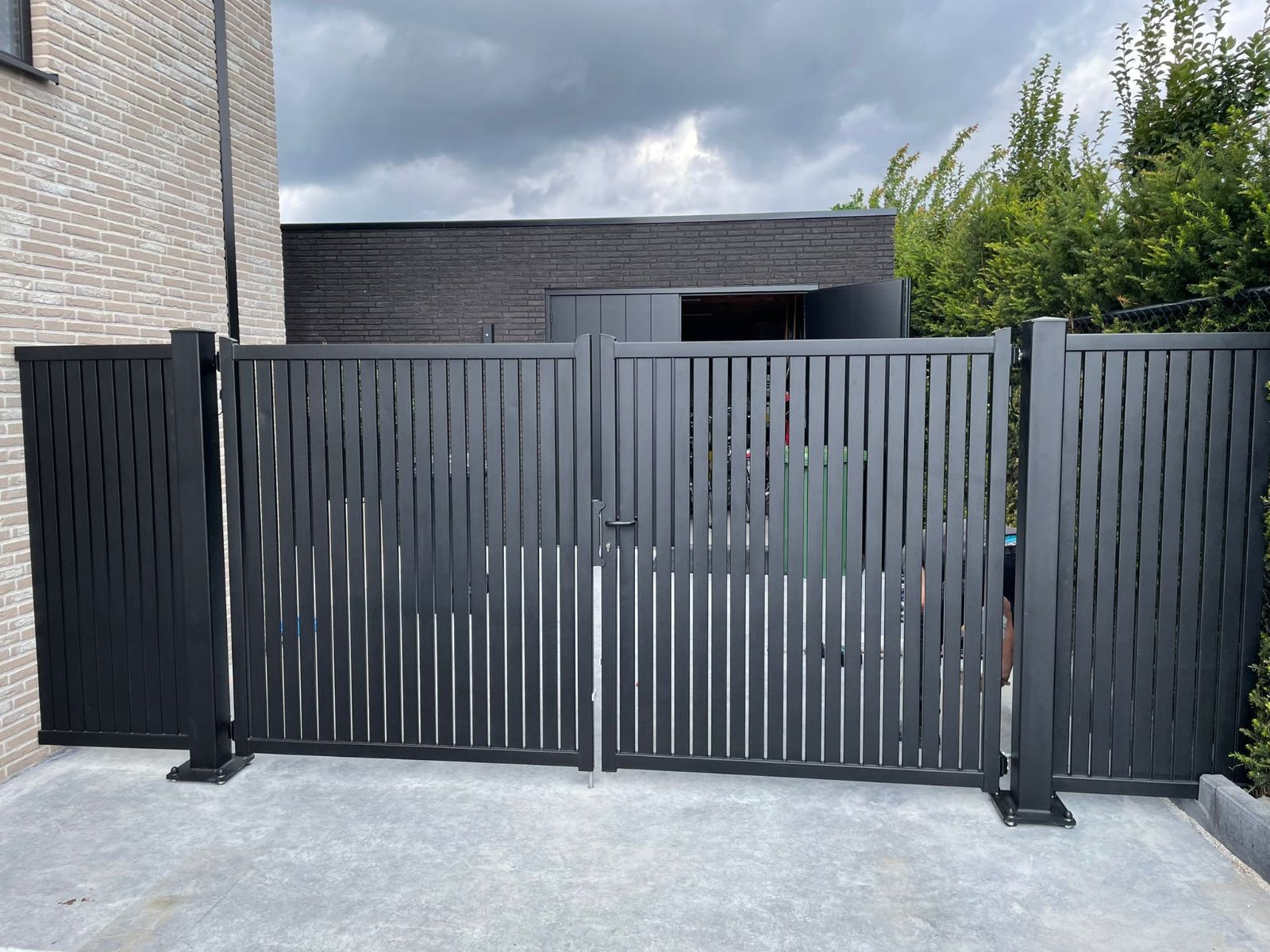 Dubbele stalen draaipoort met verticale spijlen voor een moderne woning